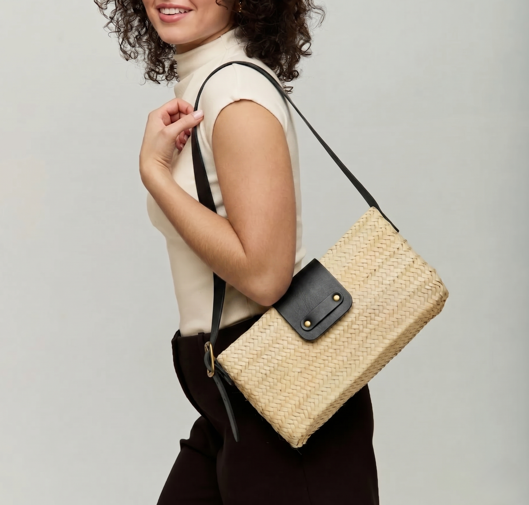 Asmae Baguette Bag worn on the shoulder in handwoven palm leaf with black calfskin