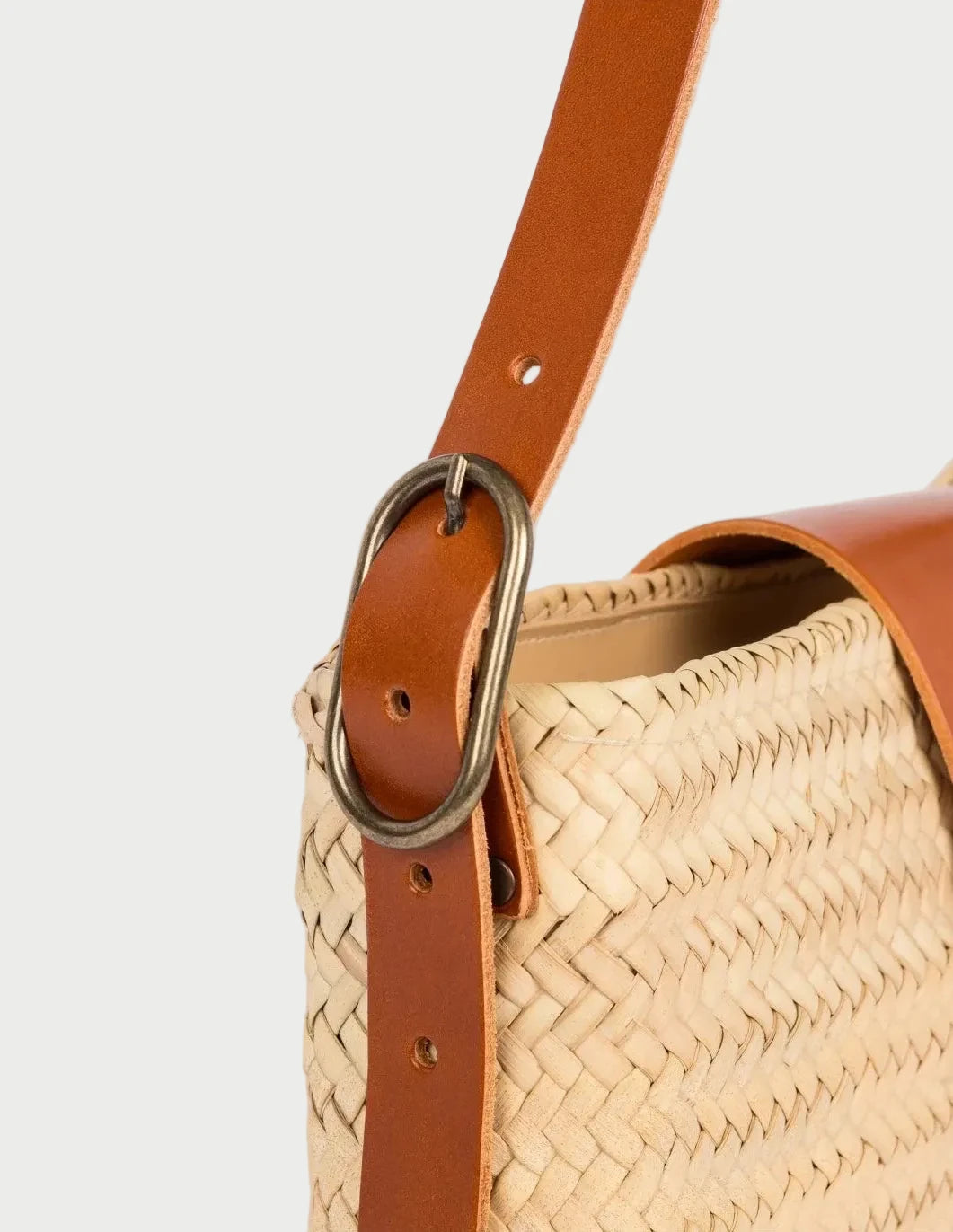 Antique brass buckle on the adjustable light brown calfskin strap of the Asmae Baguette Bag