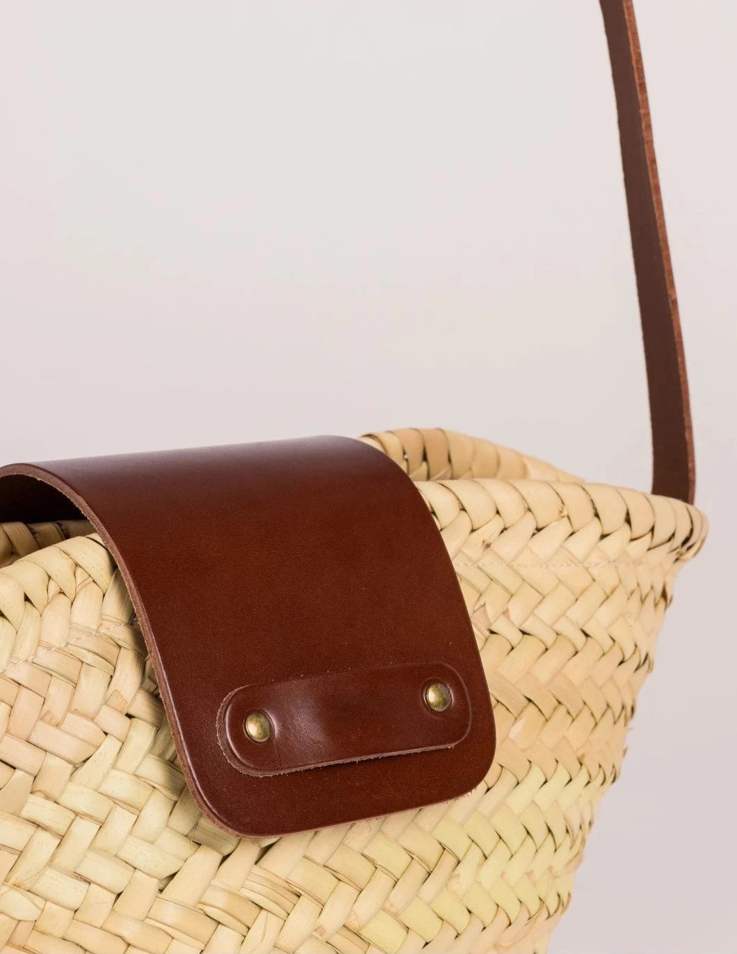 Close-up of the dark brown calfskin flap and rivet detail on the Dija Crossbody