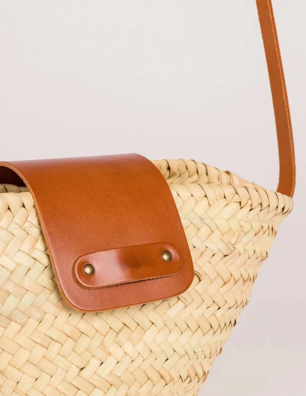 Close-up of the light brown calfskin flap and rivet detail on the Dija Crossbody