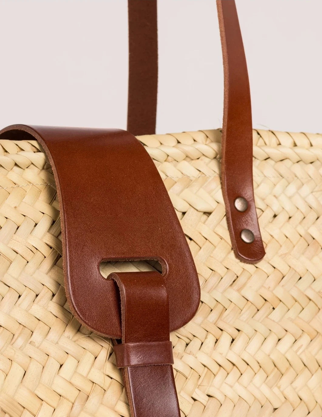 Close-up of the dark brown calfskin front strap and trim on the Fadma Large