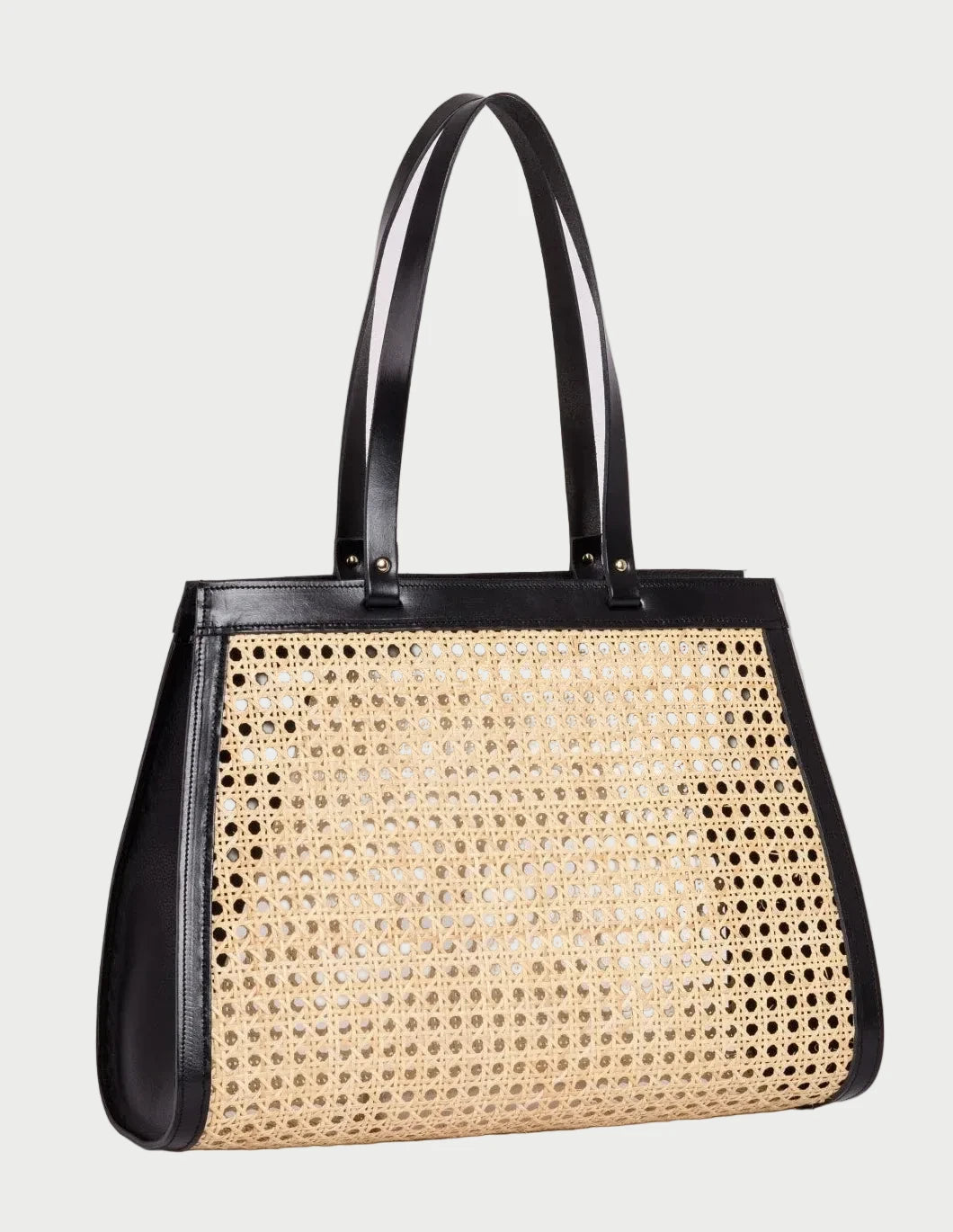 Lamia rattan cane tote with black leather trim, three-quarter angle