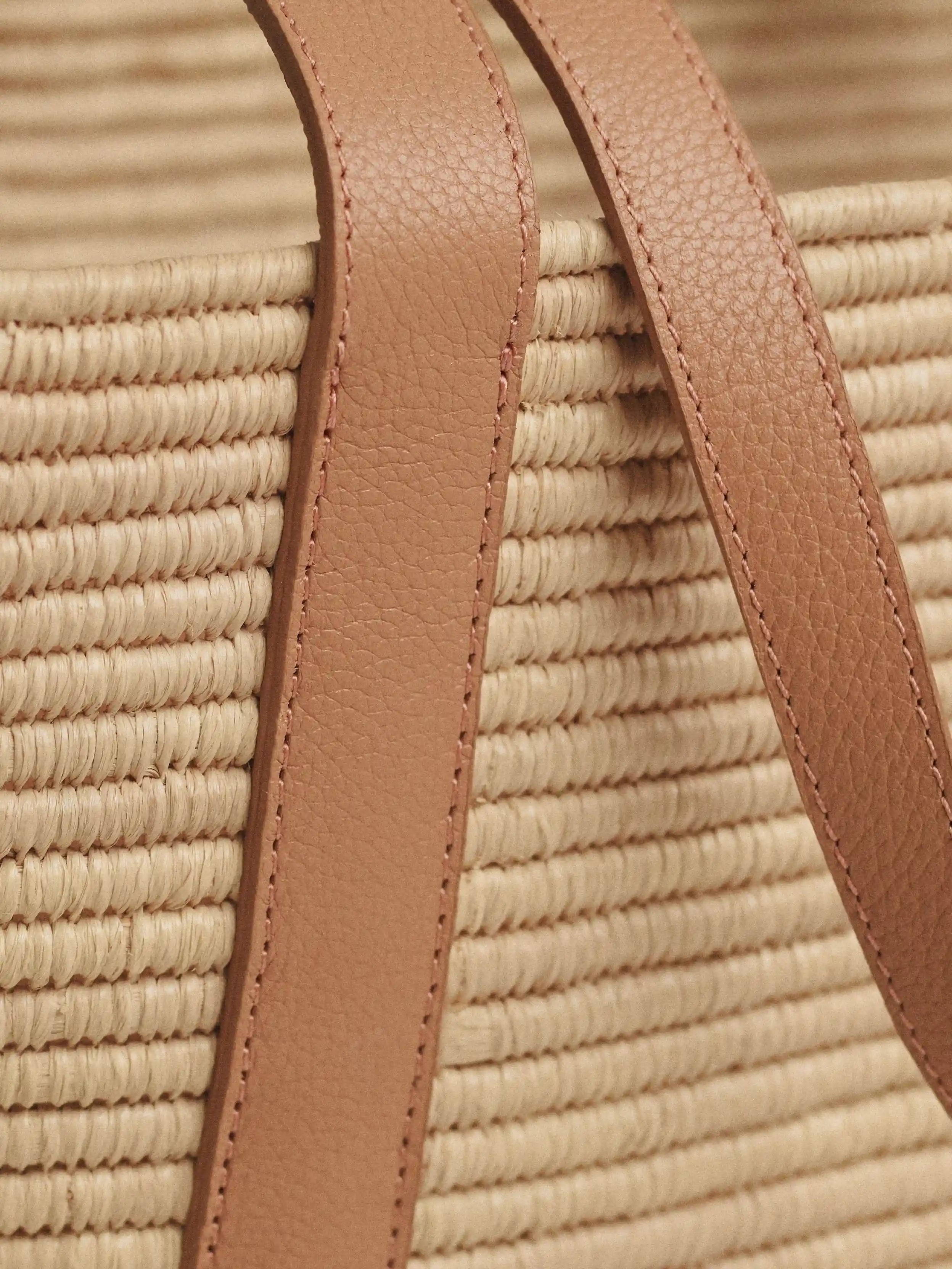 Detail of full-grain calfskin strap stitched onto the Kenza raffia basket tote
