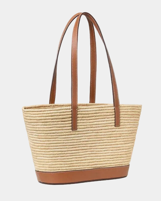 Handwoven raffia basket tote with cognac leather shoulder straps raised, front view