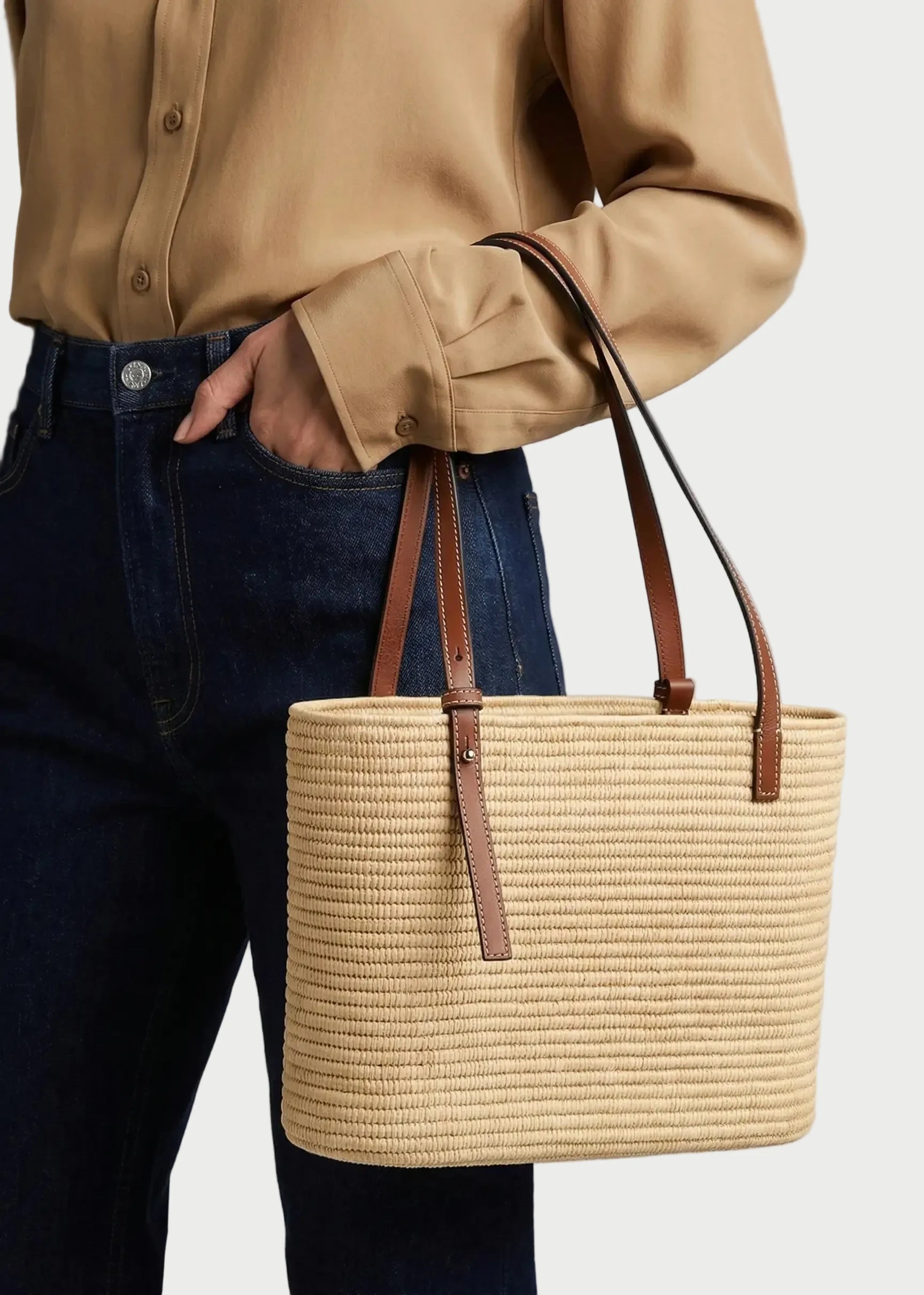 Model carrying the brown Yasmine Raffia Tote on the shoulder