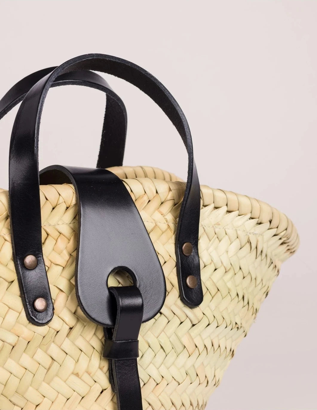 Close-up of the black calfskin front strap and trim on the Zahira Mini Basket Bag
