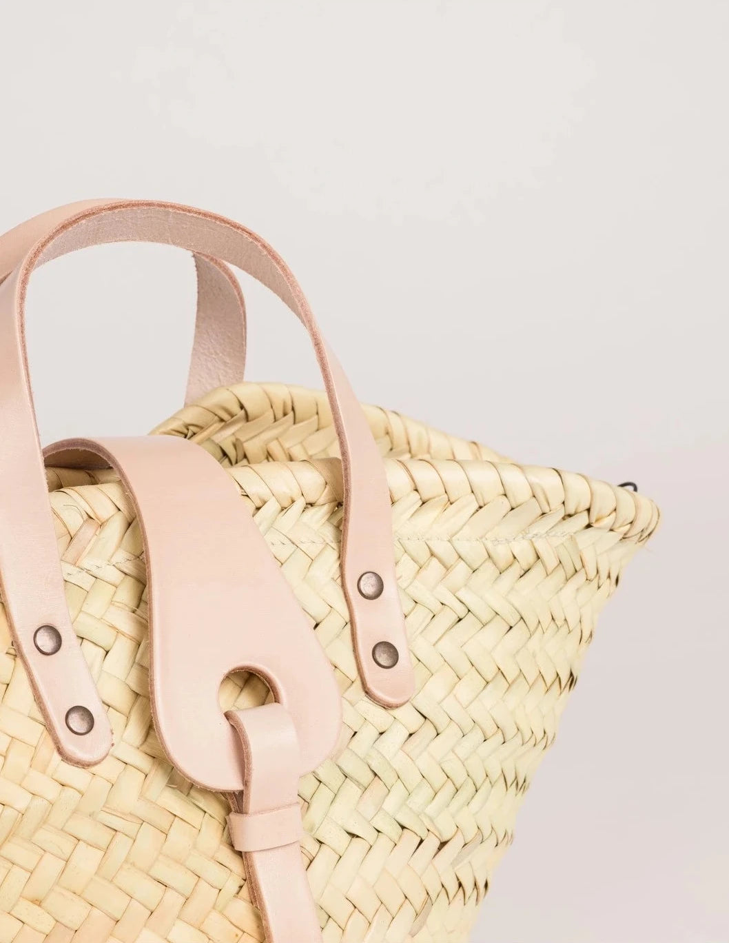 zoom view of the Zahira Mini basket bag in palm leaf with natural calfskin handles