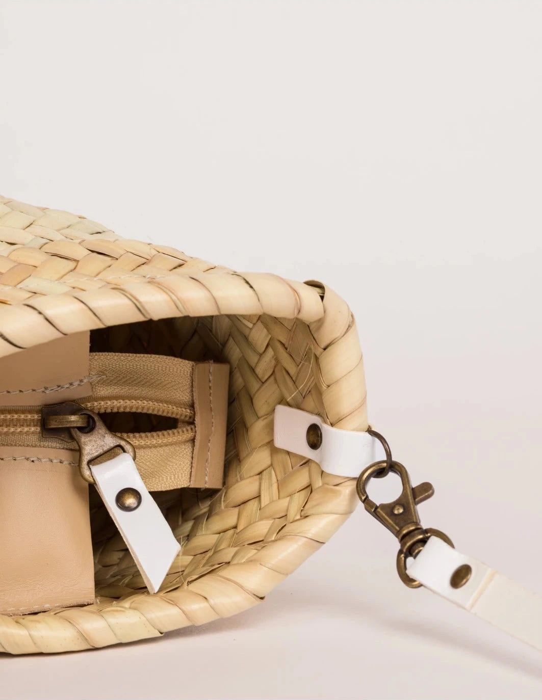 Close-up of the white calfskin front strap and trim on the Zahira Mini Basket Bag
