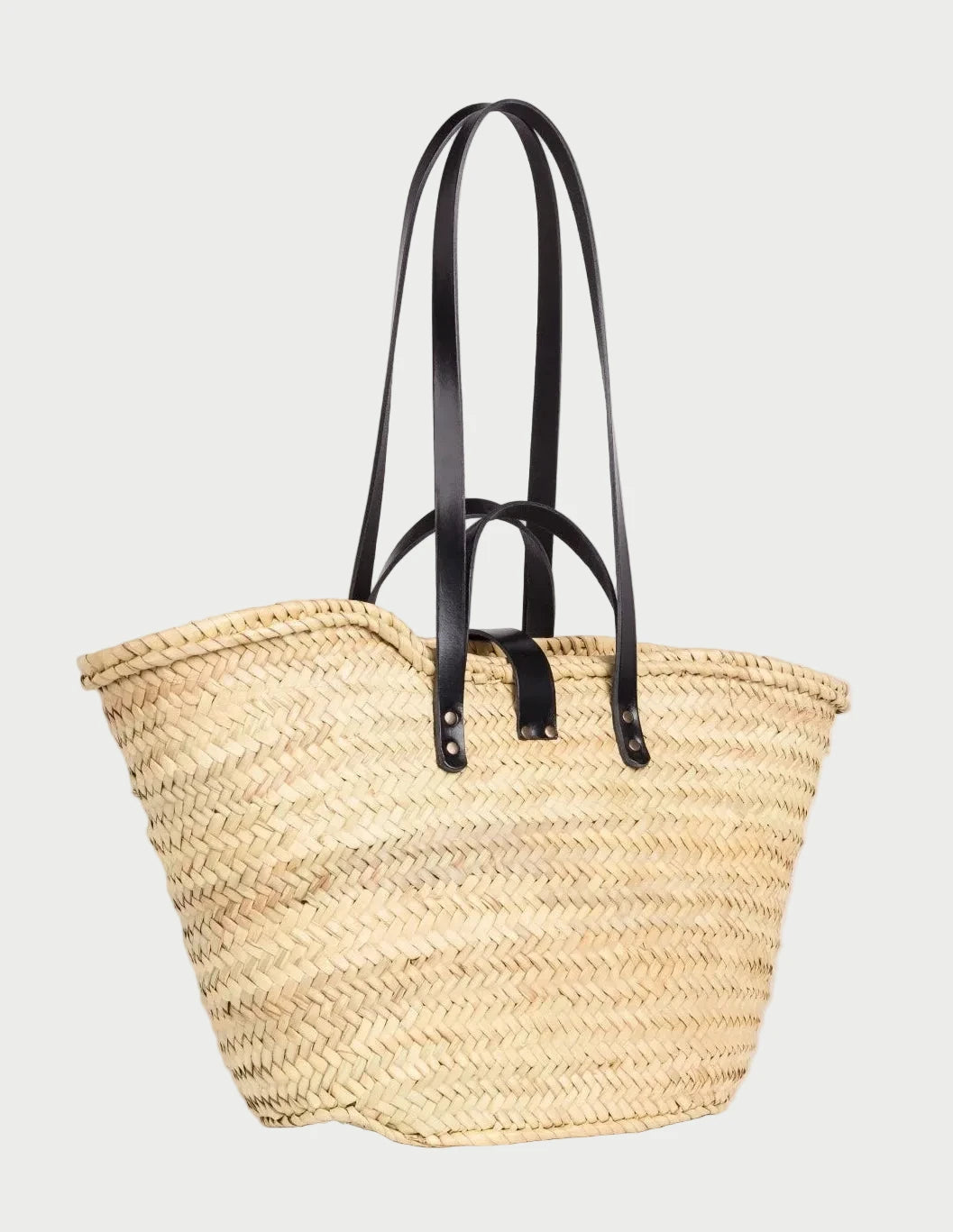 Back view of the Zhour Large palm leaf basket bag showing the woven doum palm and black calfskin straps