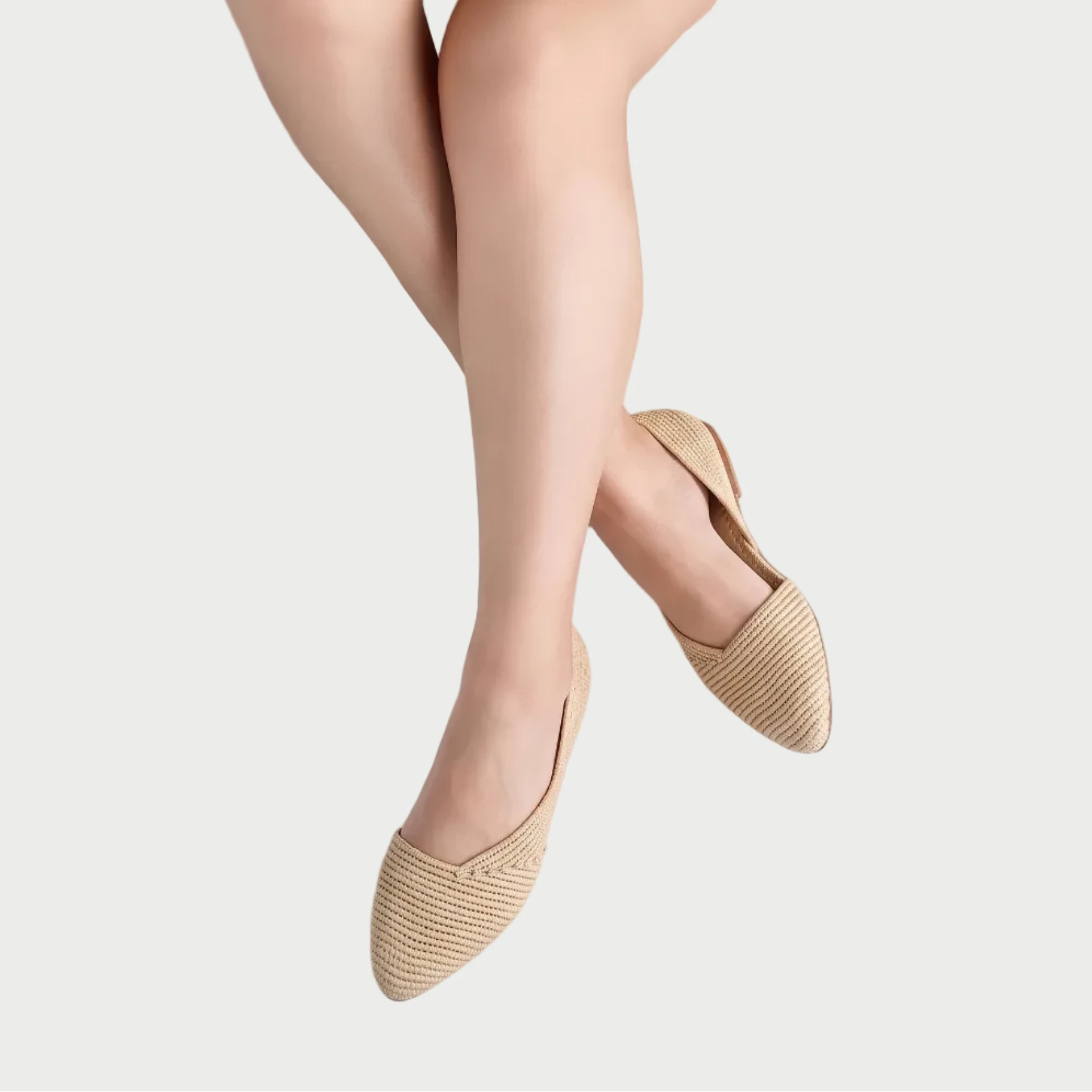 Seated model in beige dress wearing Zineb natural raffia pointed flats