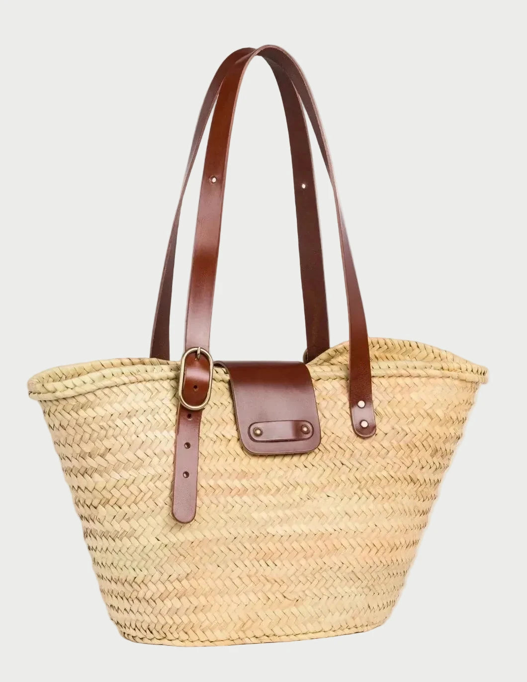 Angled view of Aicha handwoven palm leaf basket bag with dark brown calfskin leather details