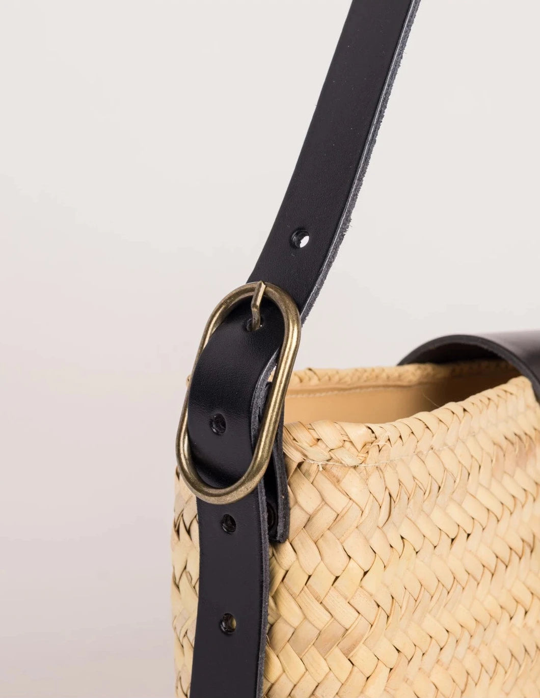 Antique brass buckle on the adjustable black calfskin strap of the Asmae Baguette Bag