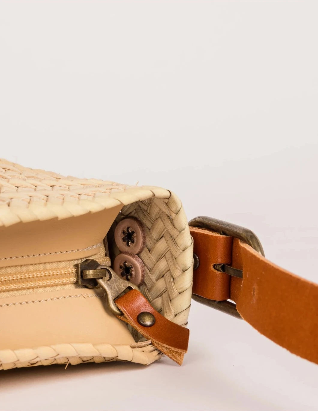 Open zip-top view of the Asmae palm leaf baguette bag showing the woven interior