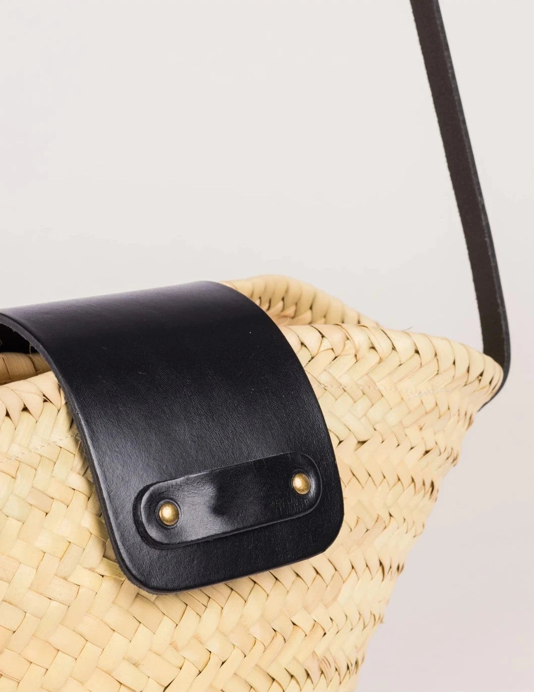 Close-up of the black calfskin flap and rivet detail on the Dija Crossbody
