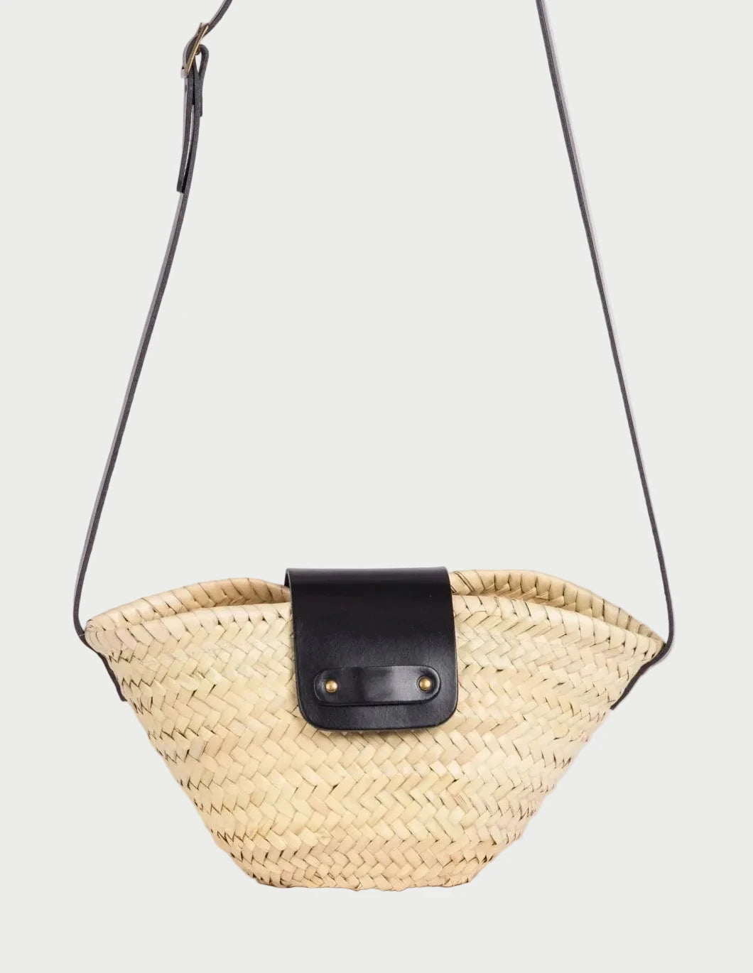Dija Crossbody palm leaf basket bag with black calfskin strap and flap front view.