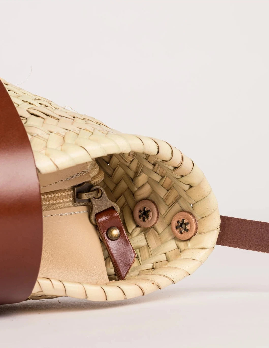 Inside view of the Dija Crossbody palm leaf basket bag with dark brown calfskin lining