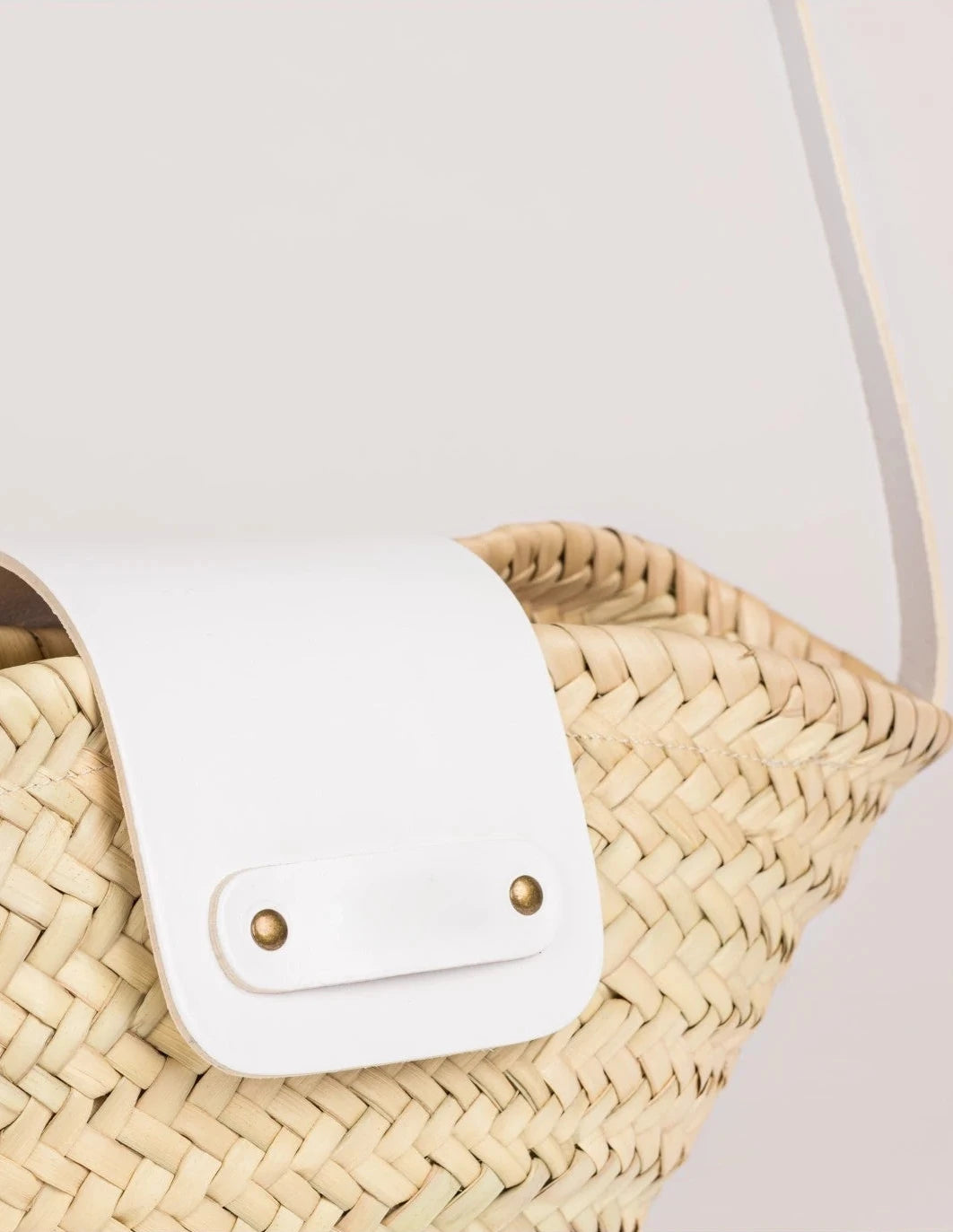 Close-up of the white calfskin flap and rivet detail on the Dija Crossbody
