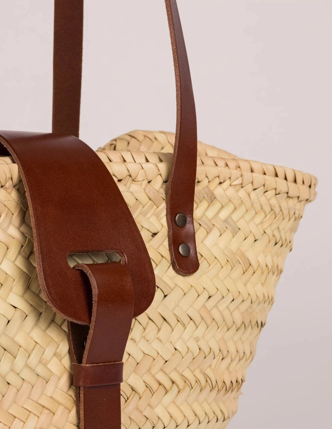 Close-up of the dark brown calfskin front strap and trim on the Fadma Small