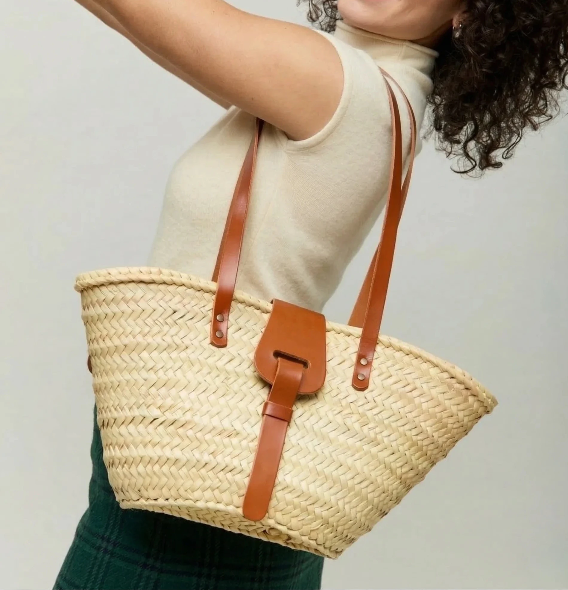 Woman carrying the Fadma Small palm leaf basket bag in light brown calfskin on the shoulder
