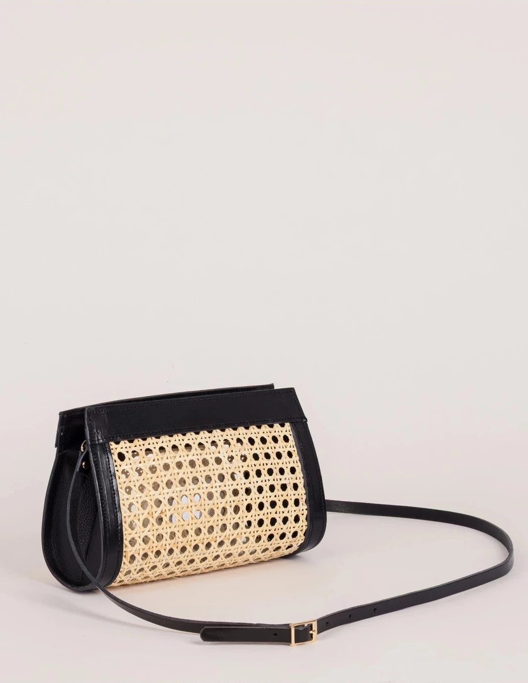 Lamia Cane Clutch shown with its detachable black leather crossbody strap, side angle