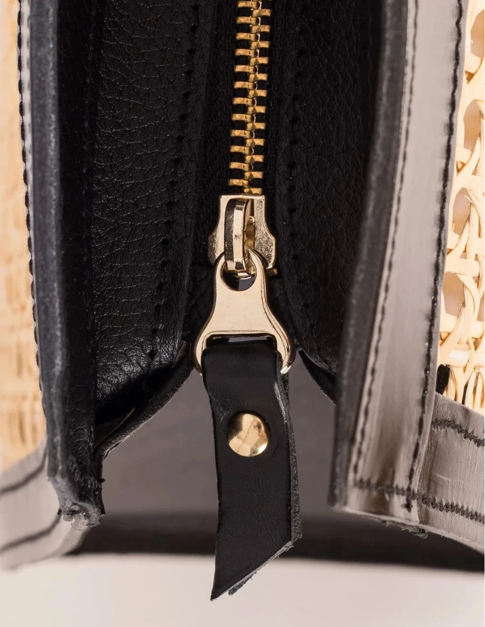 Close-up of the YKK zip closure with leather gussets on the Lamia Cane Tote #color-black
