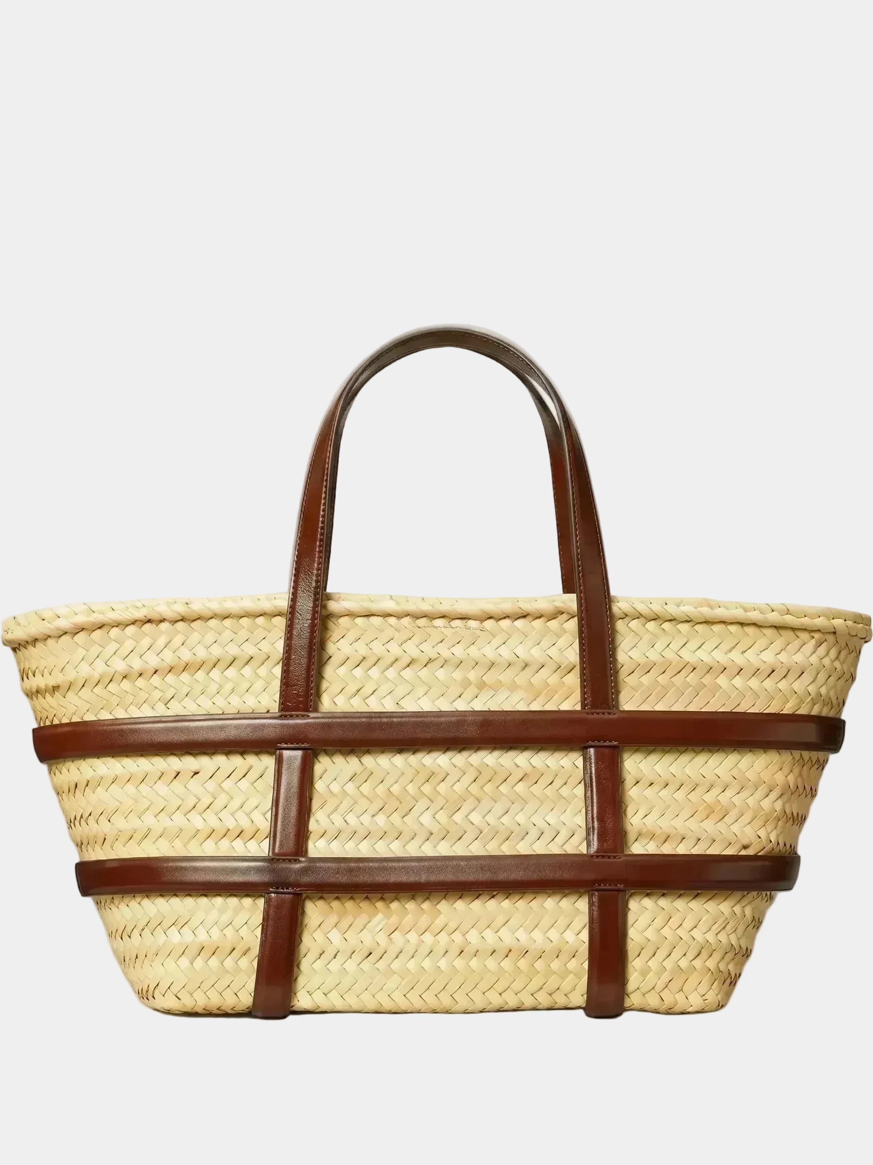 Malika handwoven palm basket tote with dark brown leather frame and handles, front view