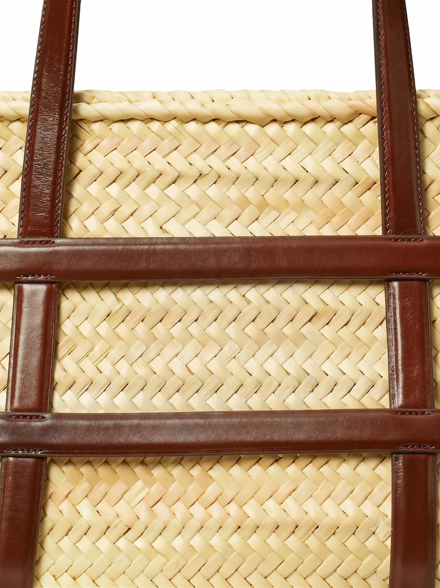 Close-up of herringbone palm weave and dark brown leather straps on Malika basket tote