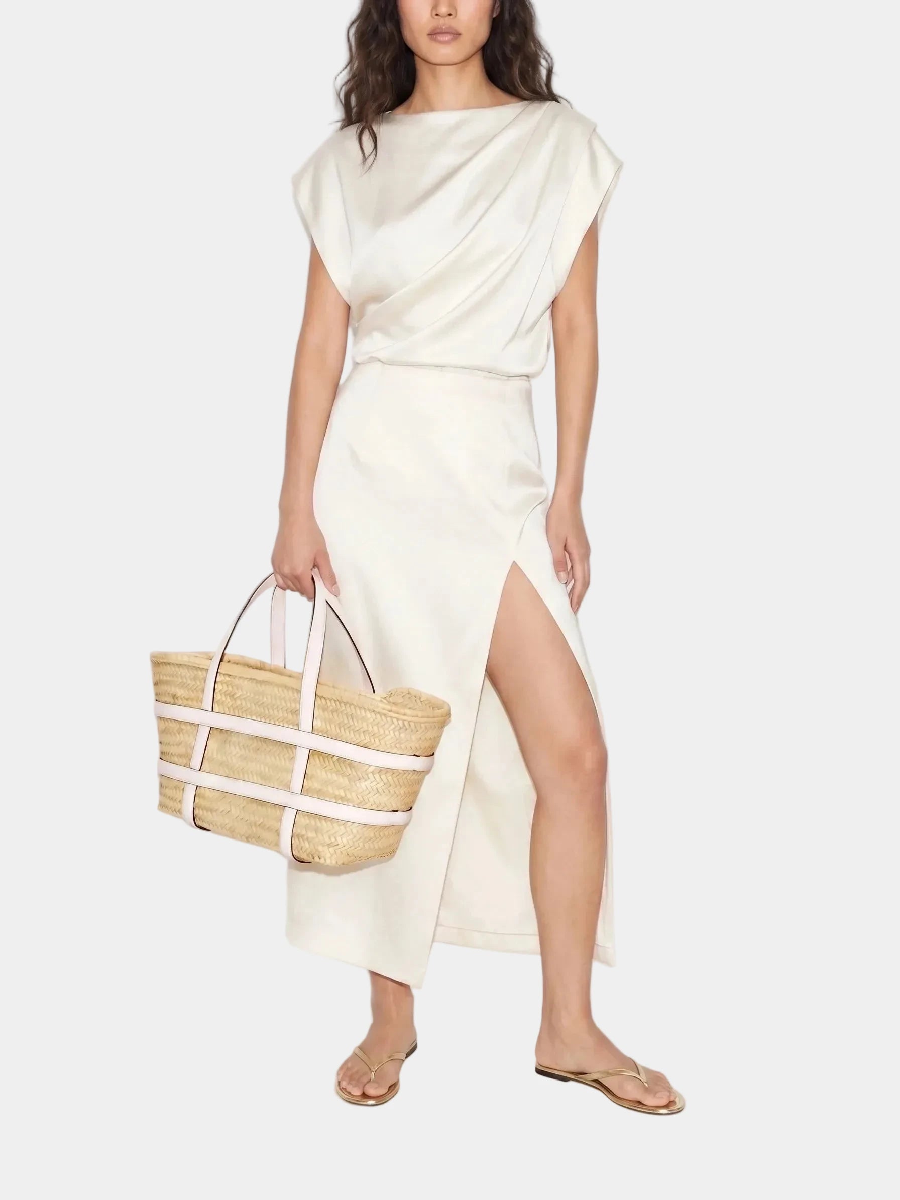 Model in white dress carrying Malika white leather basket tote

