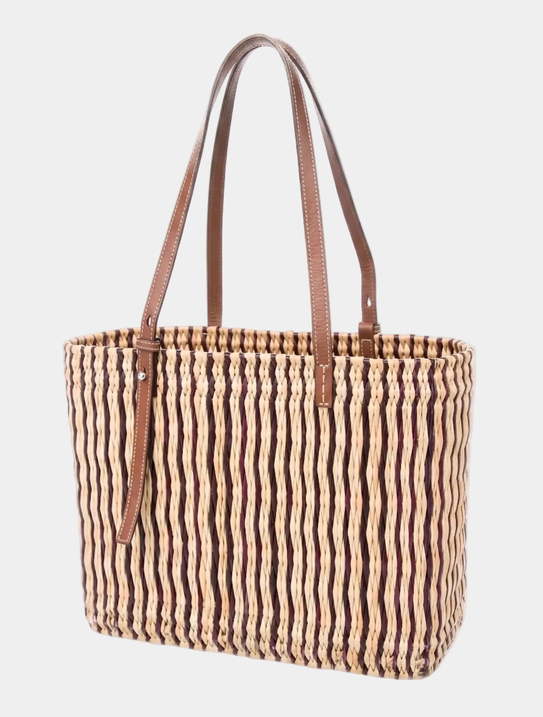 Hand-woven striped basket tote shown at a three-quarter angle with vegetable-tanned leather straps