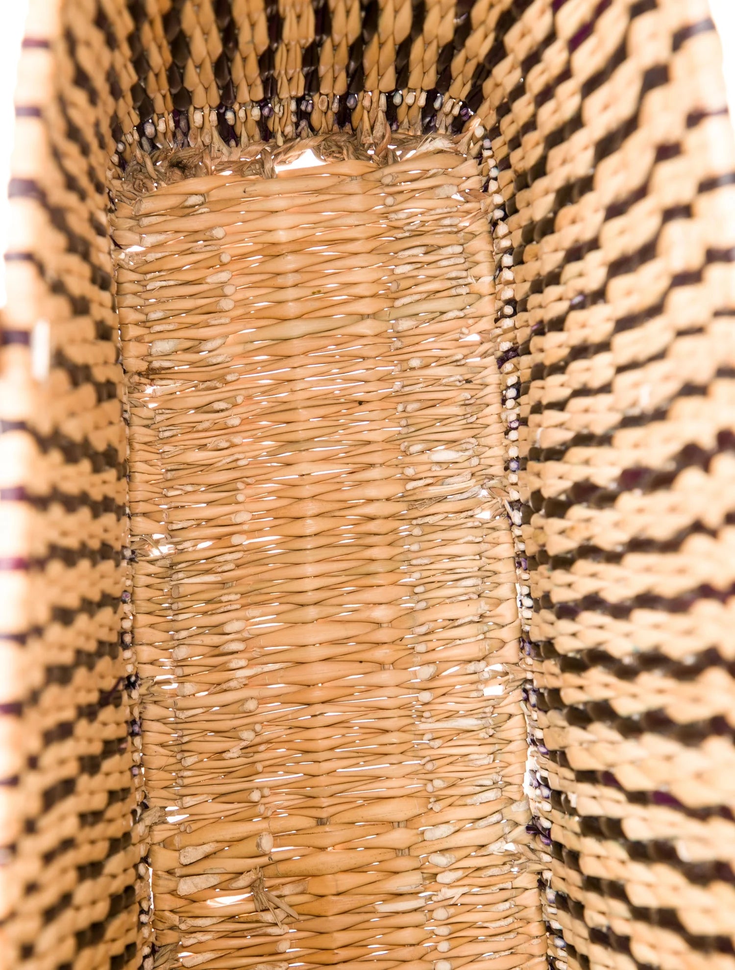 Close detail of hand-woven reed and ebony-dyed palm stripe on MARRAVIE basket tote