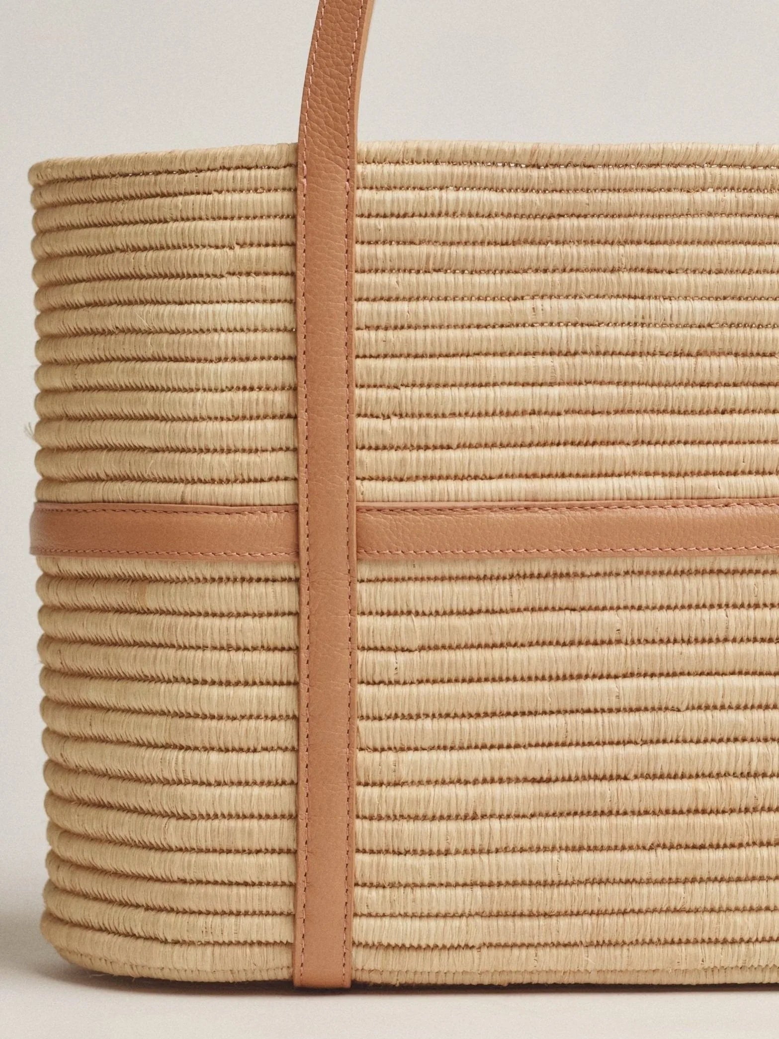 Close-up of raffia palm weave and natural beige leather strap detail on Kenza structured tote