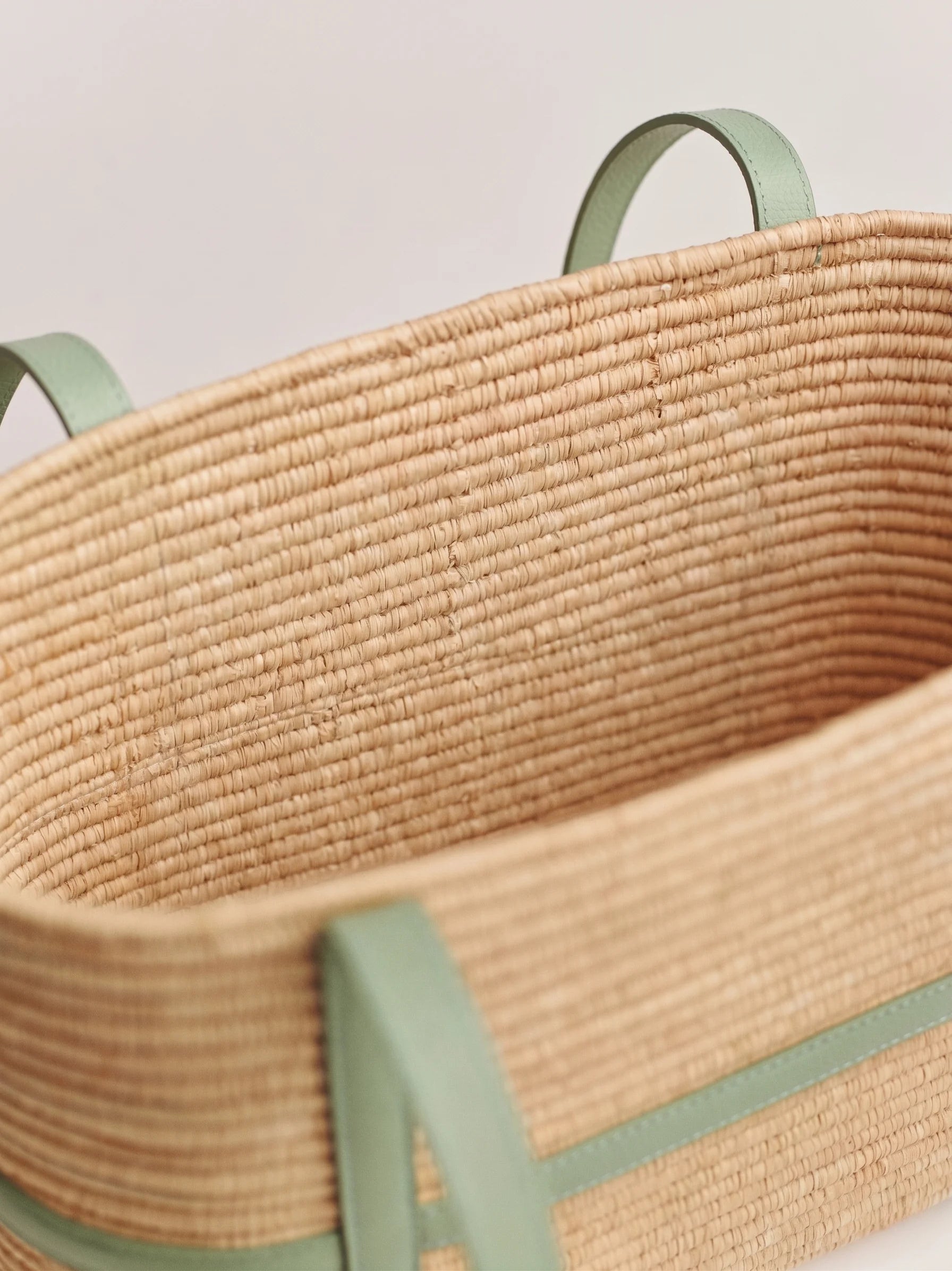 Close-up of handwoven raffia weave and sage leather strap on Kenza structured tote