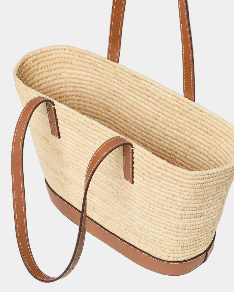 Side view of raffia basket tote showing the open top and woven depth