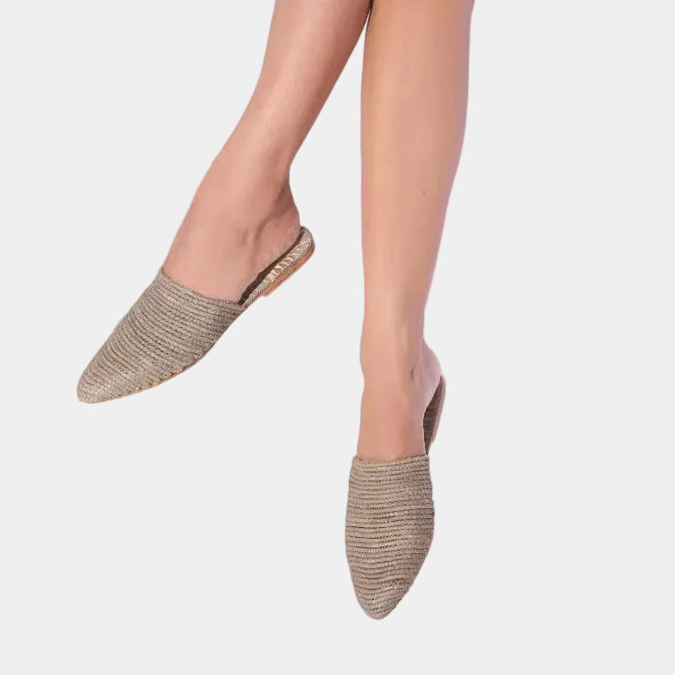 Woman wearing tobacco brown raffia babouche mules, close-up on feet — Tilila mule in Grey by MARRAVIE