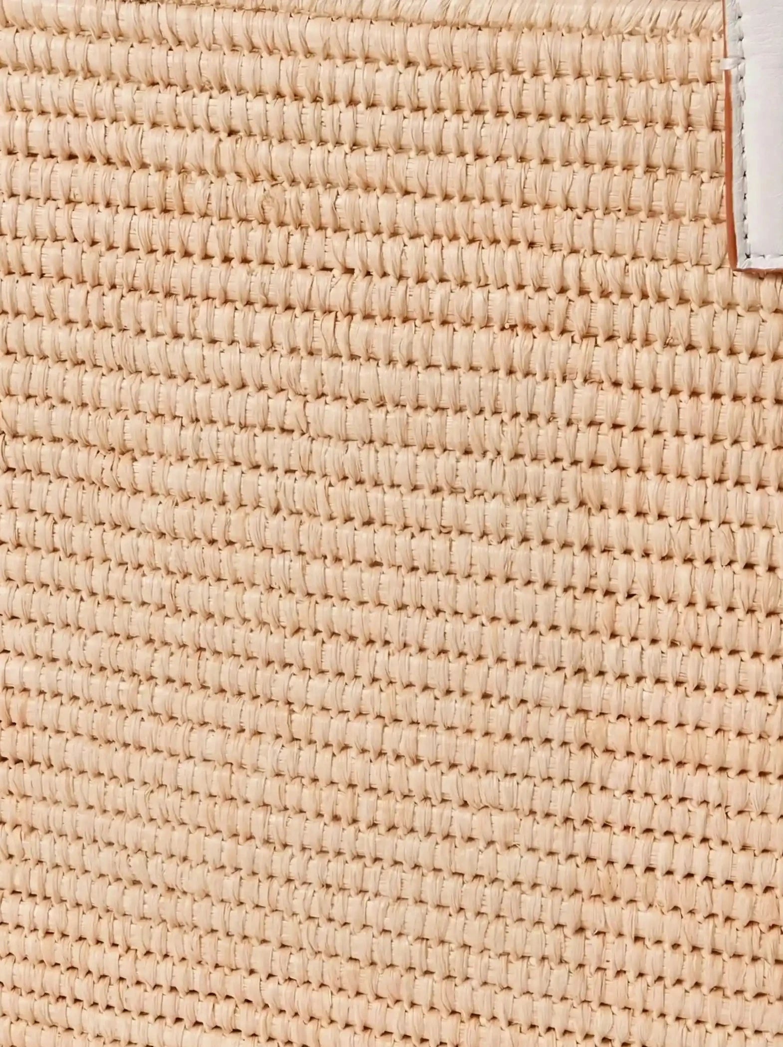 Close-up of the white handwoven raffia weave on the Yasmine Raffia Tote