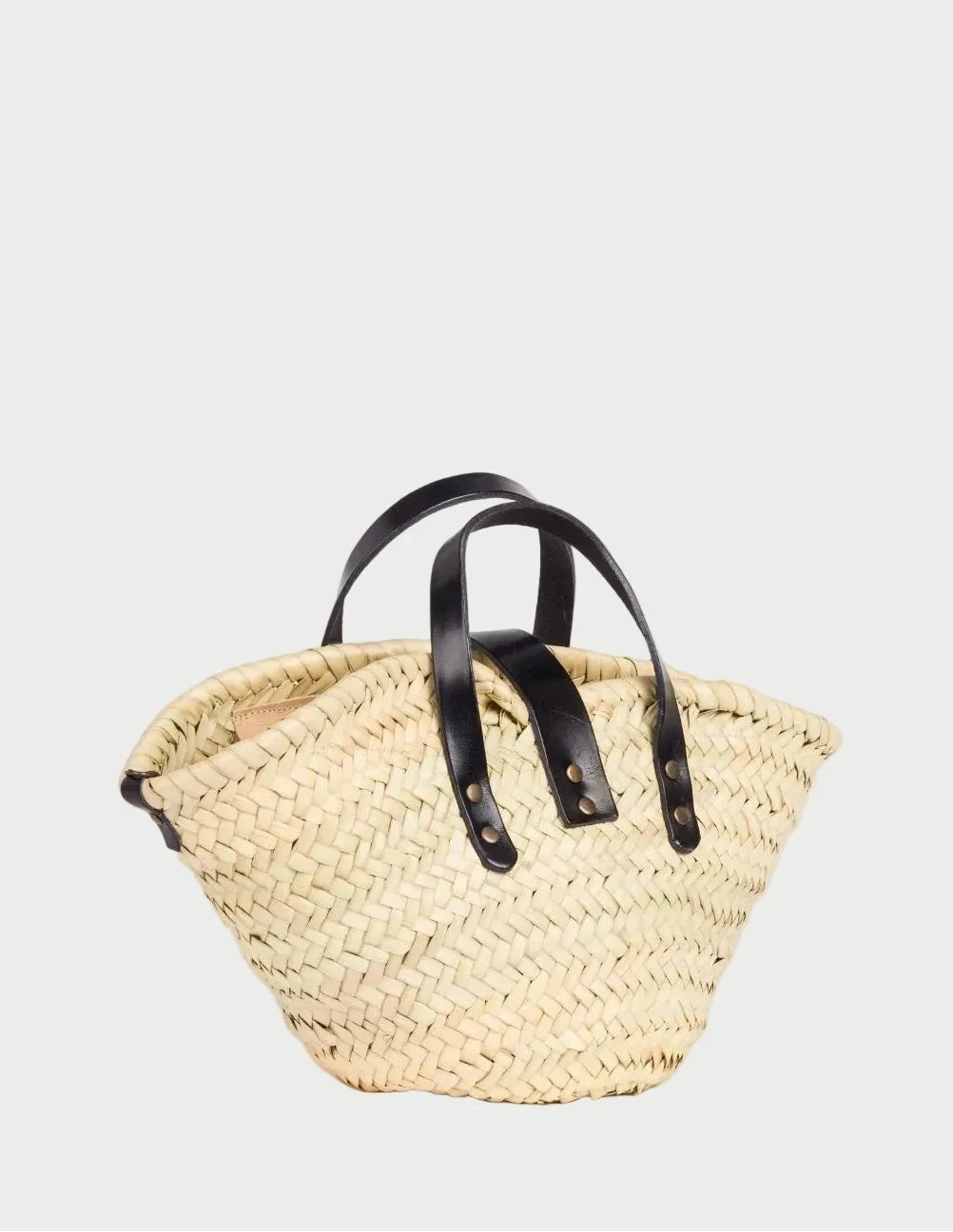 Back side view of the Zahira Mini palm leaf basket bag showing the woven doum palm and calfskin handles 
