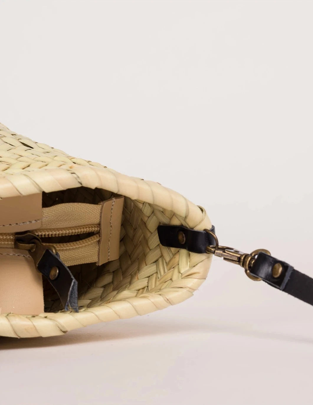 Close-up of the black calfskin front strap and trim on the Zahira Mini