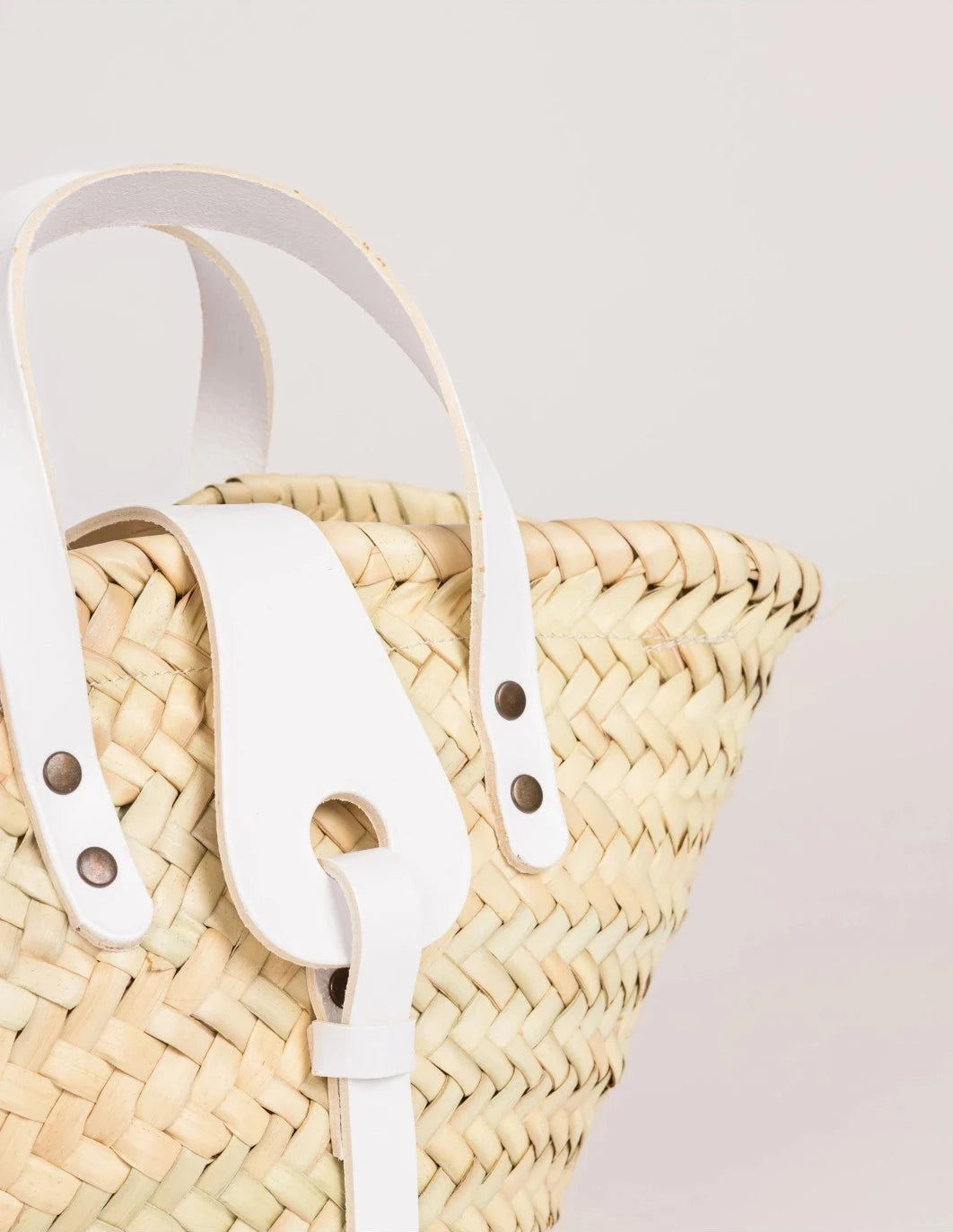 Close-up of the white calfskin front strap and trim on the Zahira Mini