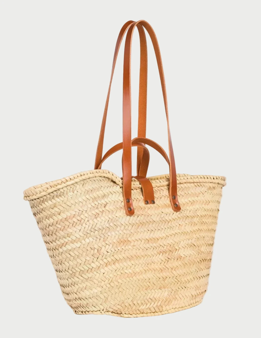 Back view of the Zhour Large palm leaf basket bag showing the woven doum palm and light brown calfskin straps