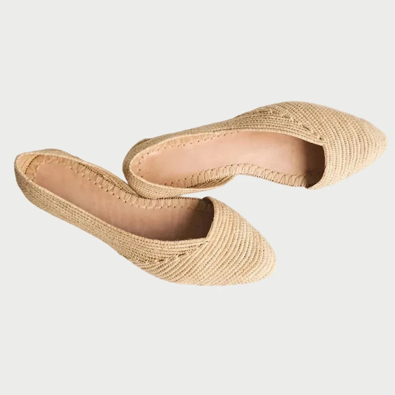 Angled view of Zineb natural raffia flats showing open side cut and woven texture